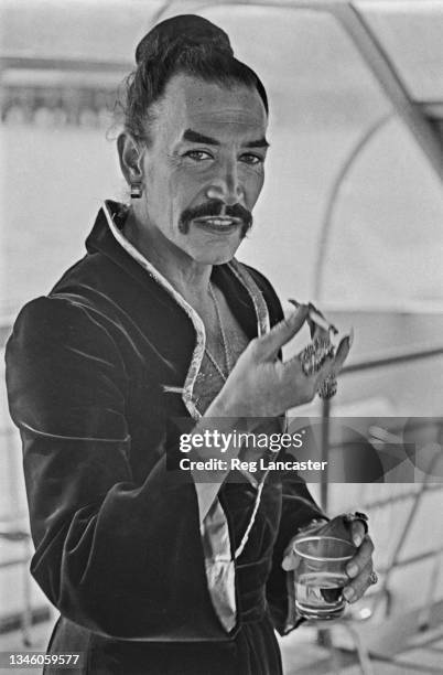 British actor Peter Wyngarde publicising his appearance as the King of Siam in the stage musical 'The King and I' on a barge on the River Thames,...