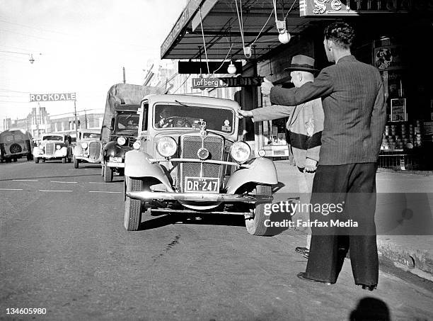 Men try to hitch a ride to the Canterbury Races as there are no trams or trains due to the coal strike on 9 July 1949.