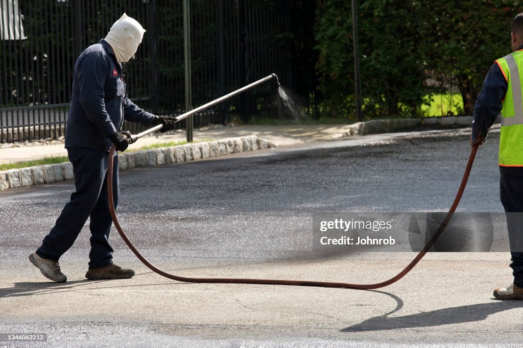 Workmen applying Asphalt Sealcoating