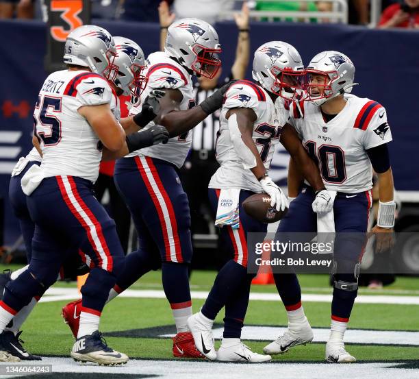 Mac Jones of the New England Patriots and Josh Uche celebrates with Damien Harris after scoring in the second half against the Houston Texans at NRG...