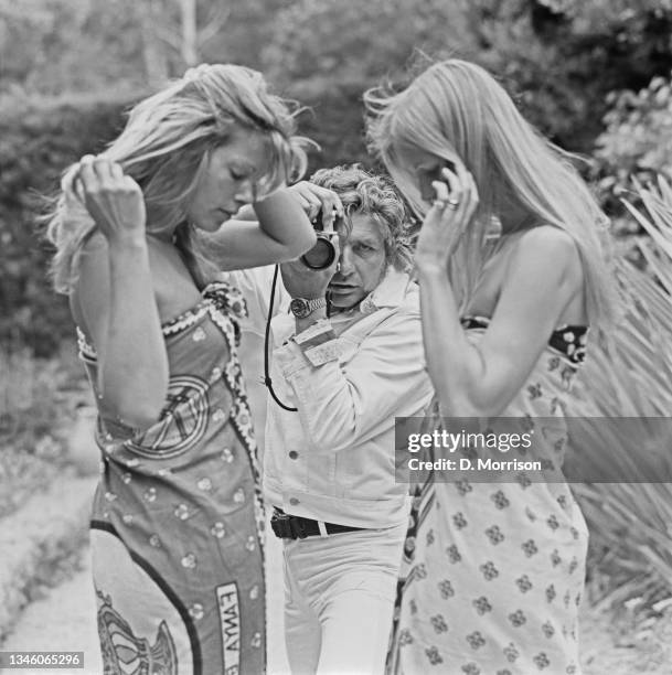 German photographer and playboy Gunter Sachs with two young female models, UK, 6th June 1973.