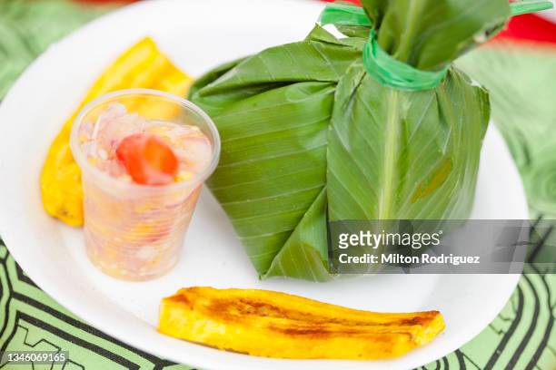 juane con arroz y pollo envuelto en hojas de plátano. comida de la selva peruana - envuelto stock pictures, royalty-free photos & images