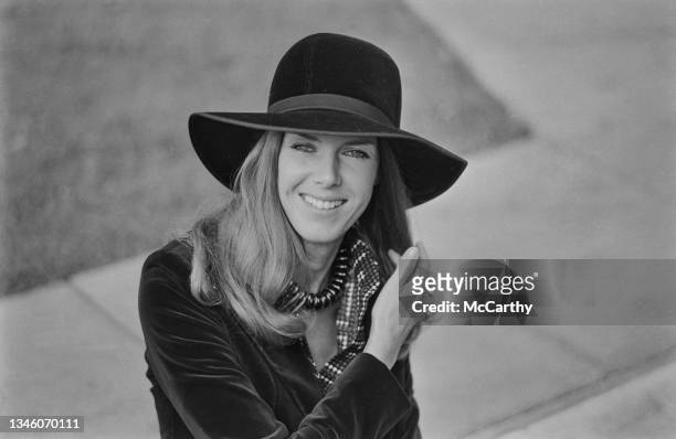 Helen Stewart, the wife of Scottish racing driver Jackie Stewart, trying on hats, UK, 7th November 1973.