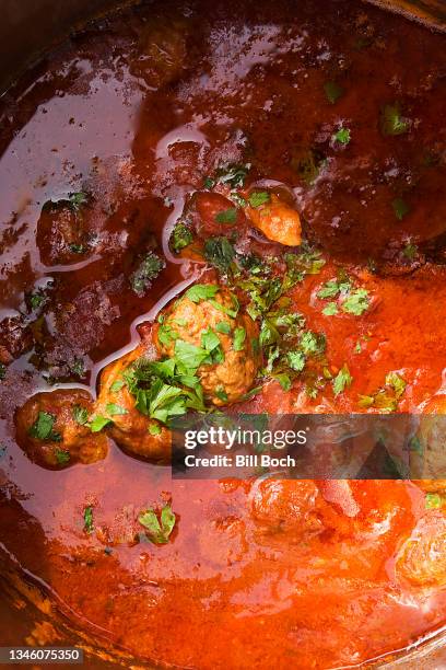 extreme close-up of a savory tomato pasta sauce with meatballs cooking - sudderen stockfoto's en -beelden