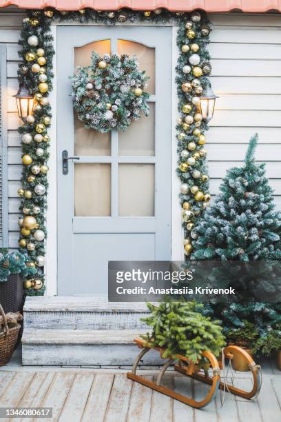 home decorated for christmas holidays with wreath trees, ornaments and garlands. - decorated christmas trees outside stockfoto's en -beelden