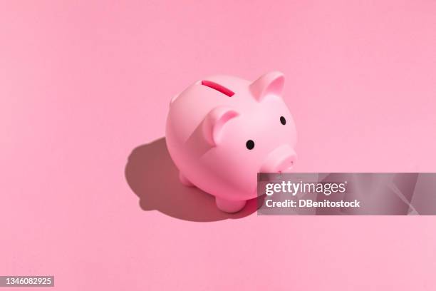 pink piggy bank with black eyes on pink background. concept of saving money, savings. - piggy bank stock pictures, royalty-free photos & images