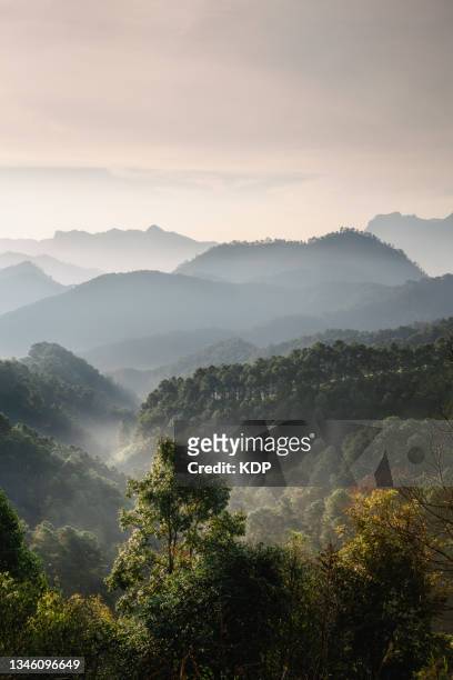 scenic nature of majestic mountain range with light haze at sunrise. - moody sky stock pictures, royalty-free photos & images