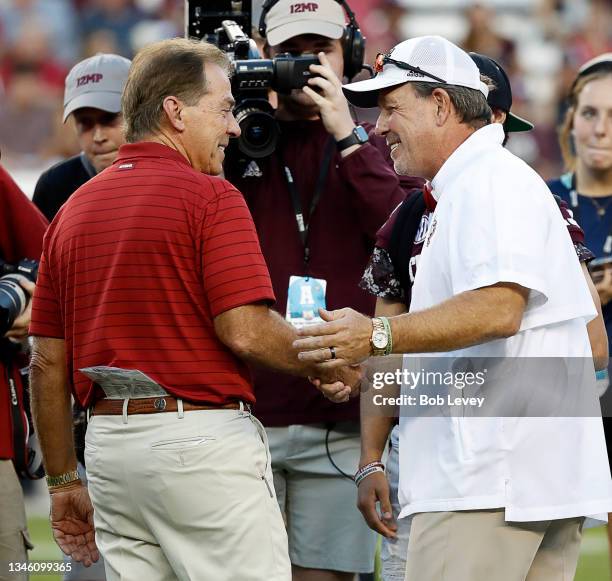 Head coach Nick Saban of the Alabama Crimson Tide meets with head coach Jimbo Fisher of the Texas A&M Aggies at Kyle Field on October 09, 2021 in...
