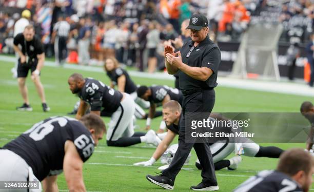 Head coach Jon Gruden of the Las Vegas Raiders talks to his players as they stretch before a game against the Chicago Bears at Allegiant Stadium on...