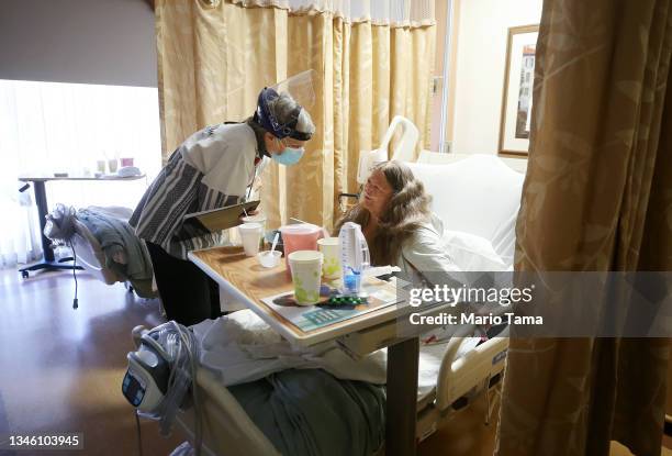 Sister Terry Maher, a chaplain, provides spiritual care for a patient in a non-COVID zone at Providence St. Mary Medical Center on February 4, 2021...