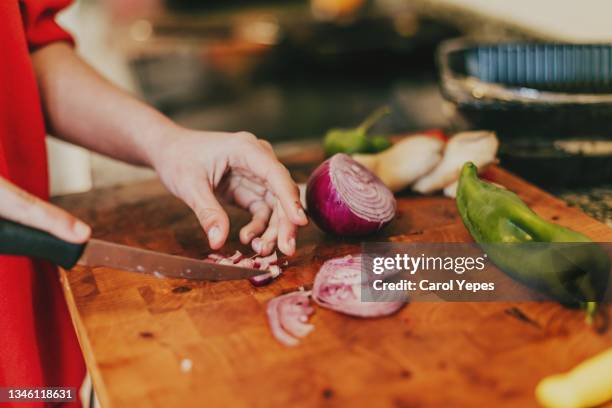 chopping onions with a kitchen knife on wooden cutting... - griechische küche stock-fotos und bilder