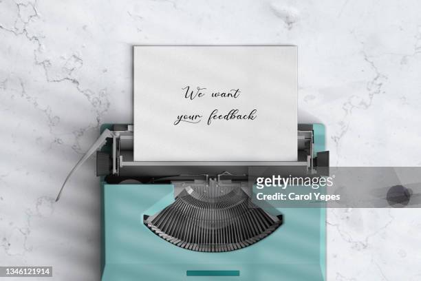 we want  your feedback in old typewriter.white marble surface - story telling in the workplace stock pictures, royalty-free photos & images