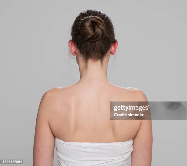 vista trasera de mujer mediana adulta con moño de pelo - moño fotografías e imágenes de stock