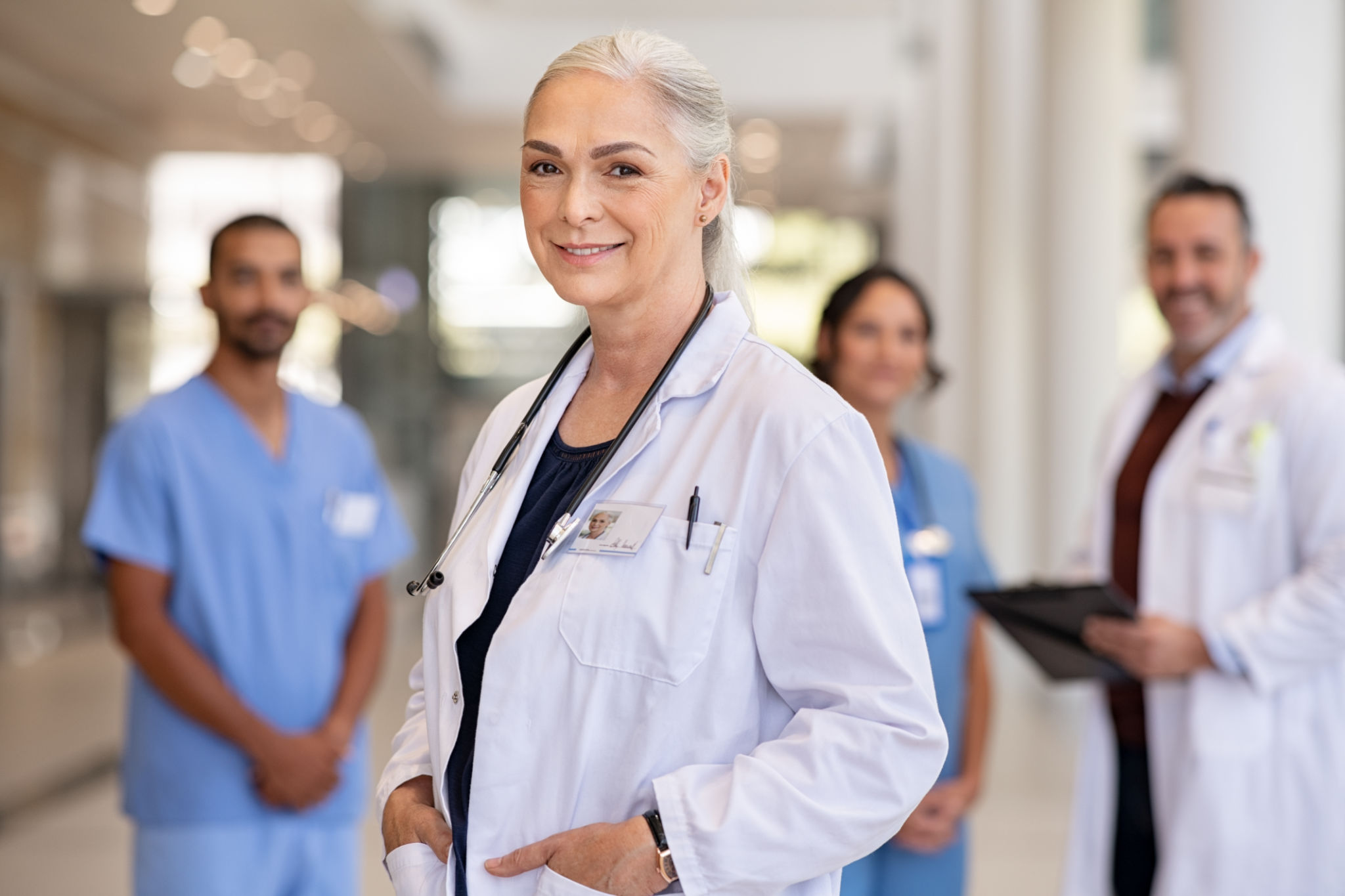 Senior confident doctor with his medical staff at hospital Senior confident doctor with his medical staff at hospital