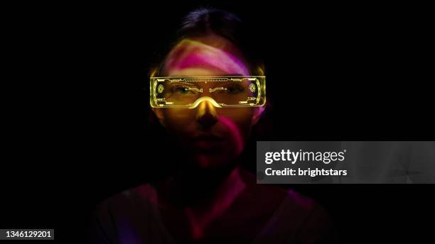 projection on a woman's face wearing futuristic glasses - vr imagens e fotografias de stock