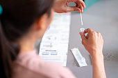 Asian woman using rapid antigen test kit for self test COVID-19 epidemic at home.