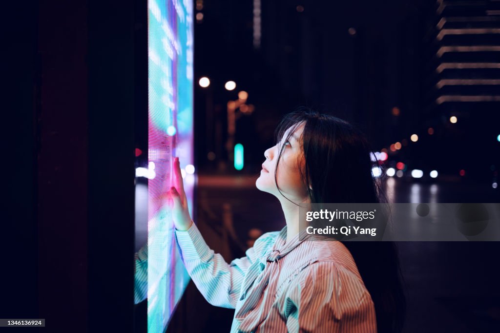 Young woman using touch screen on the street in Shanghai, China
