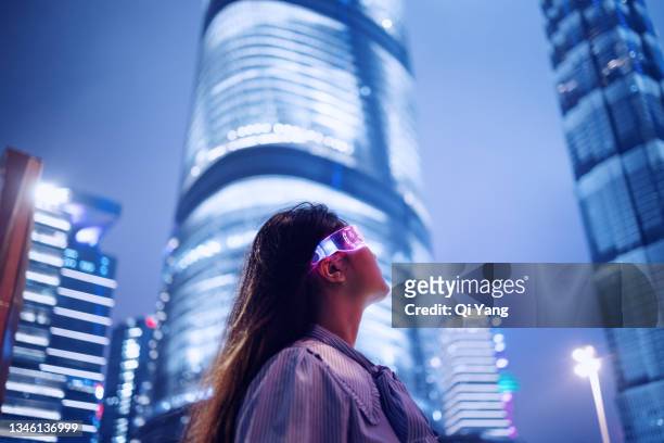 young businesswoman standing against contemporary financial skyscrapers in the downtown financial district - zukunft stock-fotos und bilder