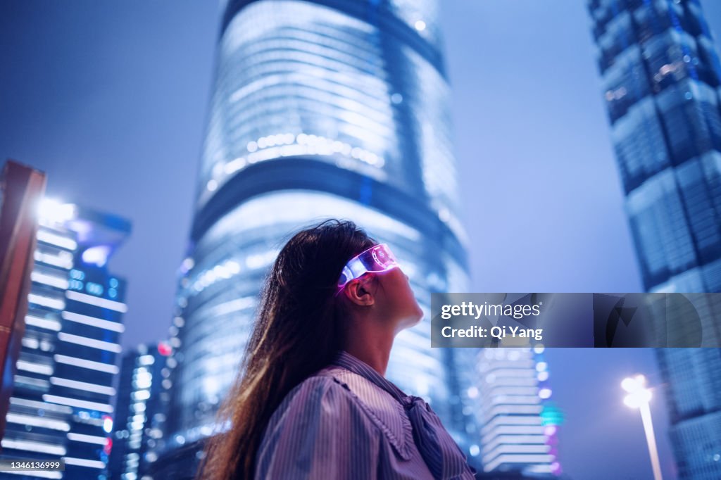 Young businesswoman standing against contemporary financial skyscrapers in the downtown financial district