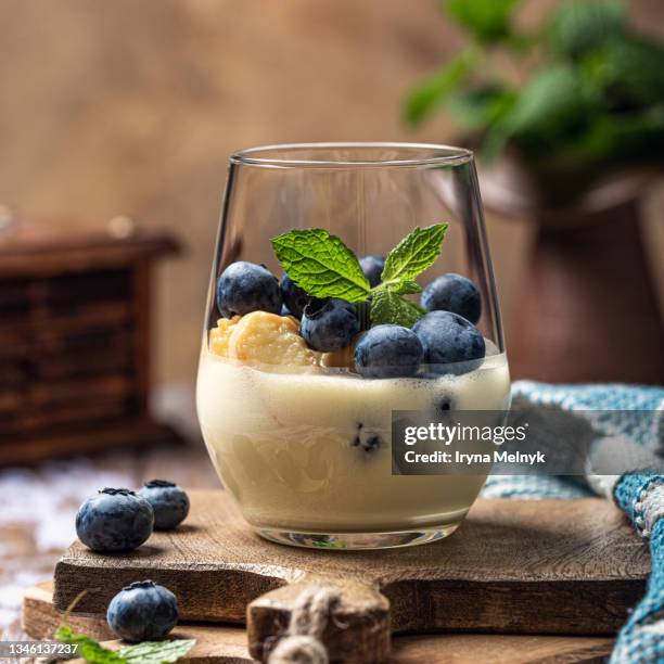 delicious homemade desert with ladyfingers cookies, fresh berries blueberry and custard cream layered in glass with mint - charlotte wood stock pictures, royalty-free photos & images