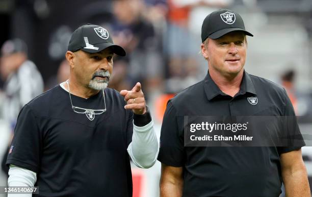 Assistant head coach/special teams coordinator Rich Bisaccia and head coach Jon Gruden of the Las Vegas Raiders talk on the field before their game...