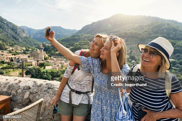 teenager-mädchen, mutter und großmutter besichtigen die schöne stadt valldemossa, mallorca, spanien - small group of people stock-fotos und bilder