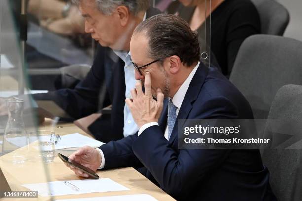 Newly appointed Austrian chancellor Alexander Schallenberg checks his phone during a special session of the Nationalrat, the Austrian parliament,...