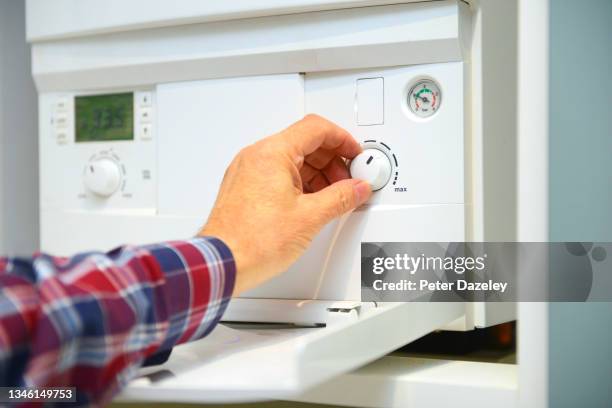 man adjusting the thermostat - cold temperature inside stock pictures, royalty-free photos & images