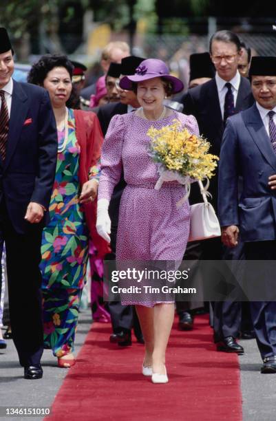 British Royal Queen Elizabeth II, wearing a lavender print dress with a wide-brim lavender hat, and Prince Philip, Duke of Edinburgh , her Private...