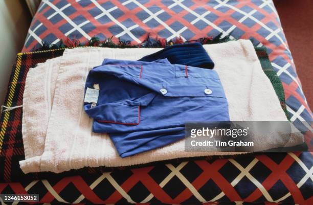 Clothes, a towel and a blanket neatly folded on a bed in a dormitory at Ludgrove School, an independent preparatory boarding school in Wokingham,...