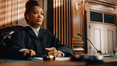 Court of Law Trial in Session: Portrait of Honorable Female Judge Reading Decision. Presiding Justice Pronouncing Sentence. Not Guilty Verdict Judgment.