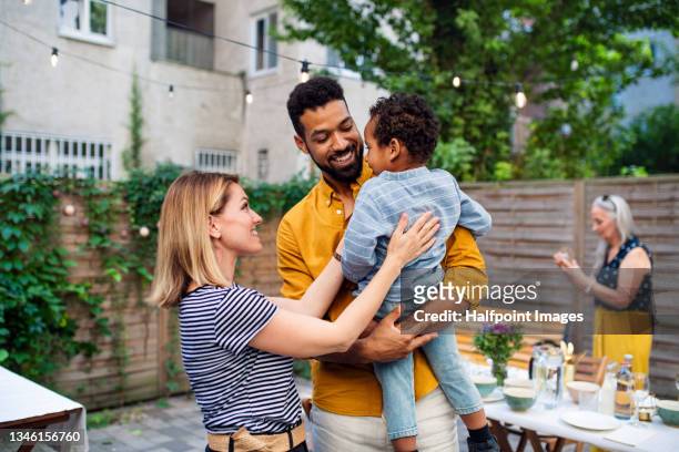happy biracial family with small son during family dinner outdoors in garden. - couple outdoors imagens e fotografias de stock