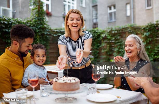portrait of multiracial three generations family celebrating birthday outdoors in front or back yard. - family back yard stockfoto's en -beelden