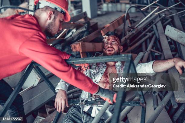 male experiencing extreme pain while getting rescued by emergency worker - serious injury stock pictures, royalty-free photos & images