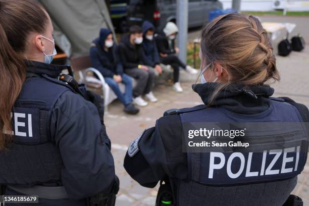 German federal police officers stand over four men who said they are from Afghanistan who had crossed illegally into Germany across the border from...