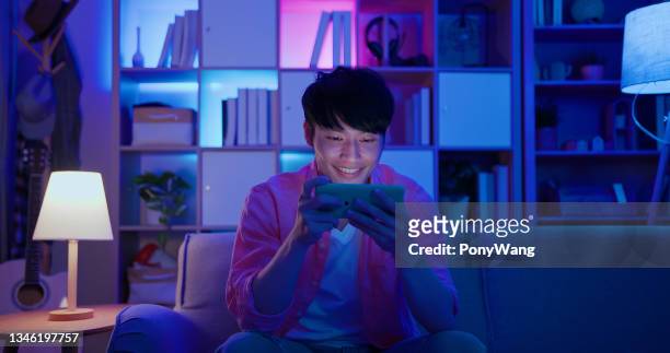 mann spielt handyspiele - chinese home stock-fotos und bilder