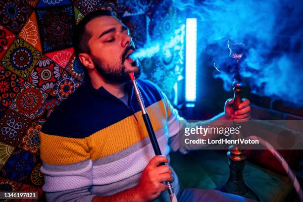 young man smoking hookah - hookah imagens e fotografias de stock
