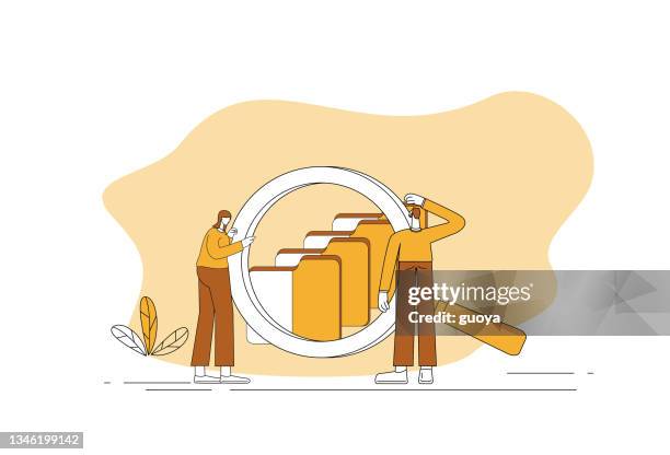 two white-collar workers use a magnifying glass to find a folder. - database search stock illustrations