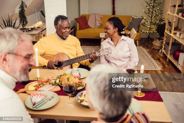 happy senior friends celebrating new year with music and a good dinner - 55 year old male stockfoto's en -beelden