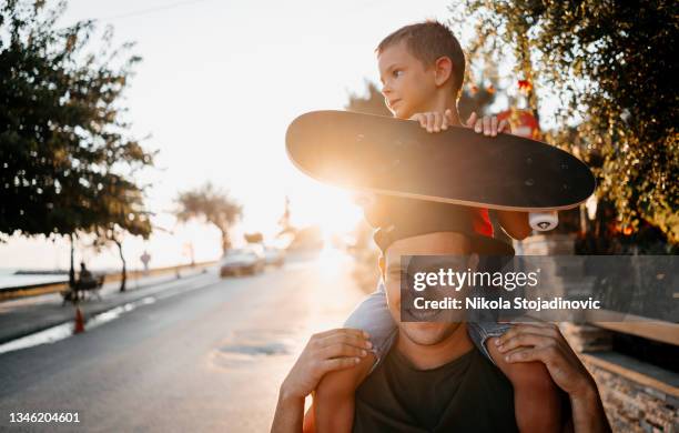 dad and son on a day out near the sea - father longboard stock pictures, royalty-free photos & images