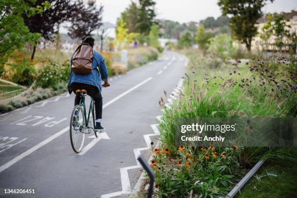 young hipster man in the urban streets commuting - bicycle lane stock pictures, royalty-free photos & images