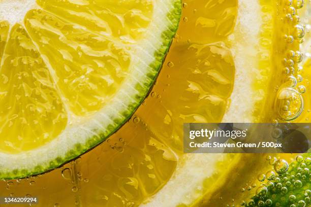 close-up of lemon slices in glass - sabor amargo fotografías e imágenes de stock