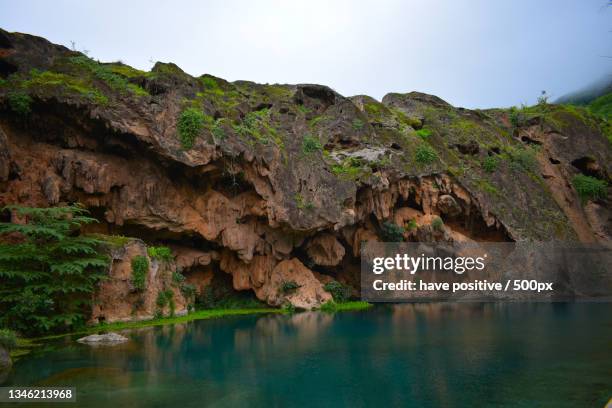 scenic view of lake by mountain against sky,salalah,oman - salalah stock pictures, royalty-free photos & images