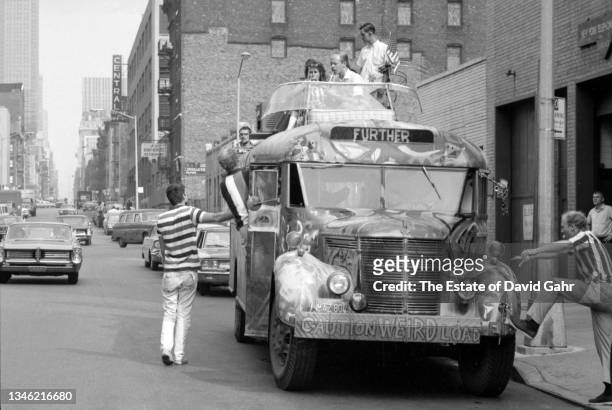 American novelist and counterculture figure Ken Kesey and members of The Merry Pranksters, stand outside of Further, the legendary Day-Glo Bus, in...