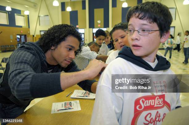 Corbin Bleu of Disney's 'High School Musical 3: Senior Year', autographs a t-shirt on 5th-grader Jonathan Temple, 10-years-old, January 23, 2009 in...