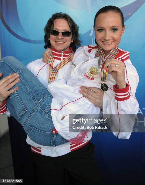 Russian skater Maxim Shabalin holds partner Oksana Domnina as she displays the gold medal they received as top ice dancing winners at the 2009 ISU...