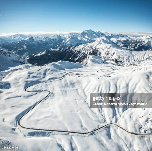 aerial view of winding road in the snow, dolomites - hairpin curve stock pictures, royalty-free photos & images