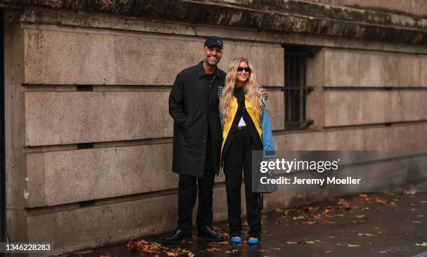 Emili Sindlev & Mads Emil Moller wearing a yellow, blue colored jacket and a black pullover, black pants and blue shoes and a black coat, pants,...