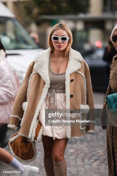 Tina Leung wearing a brown fur coat, white sunglasses and a brown bag outside Miu Miu Show on October 05, 2021 in Paris, France.