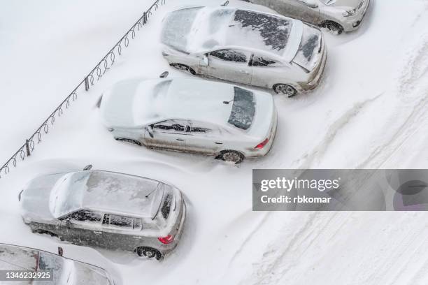 top view of snow covered cars in street parking lot - deep snow stockfoto's en -beelden